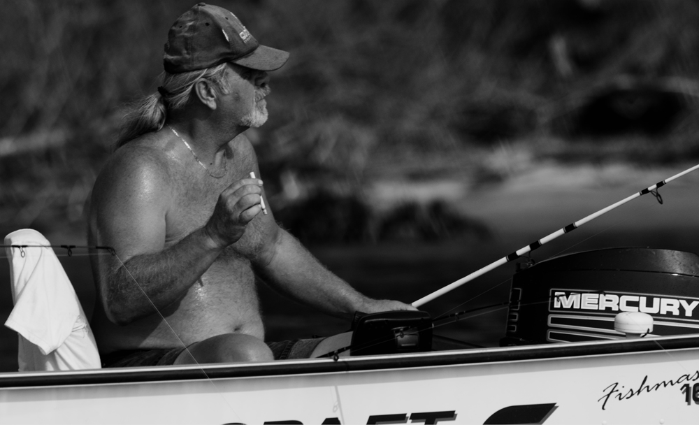 Fisherman in a small boat, black and white